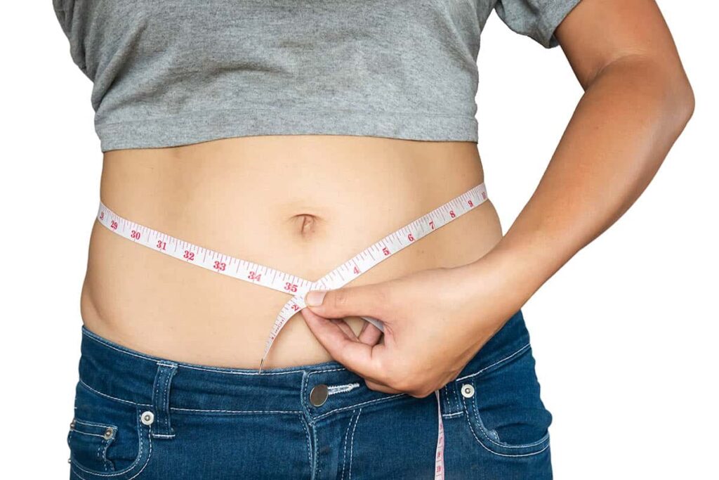 woman measures her waist overweight belly