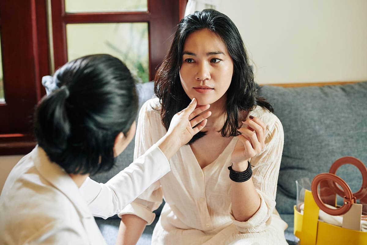 Woman touching the chin of a friend after chin reduction surgery