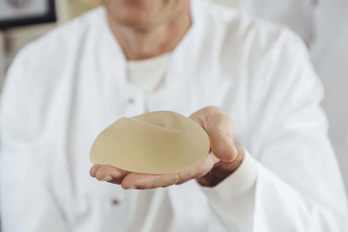 doctor showing a breast implant in his hand