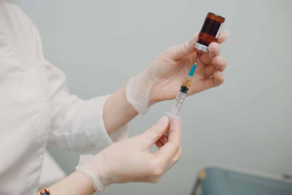 doctor extracting botox from bile into syringe