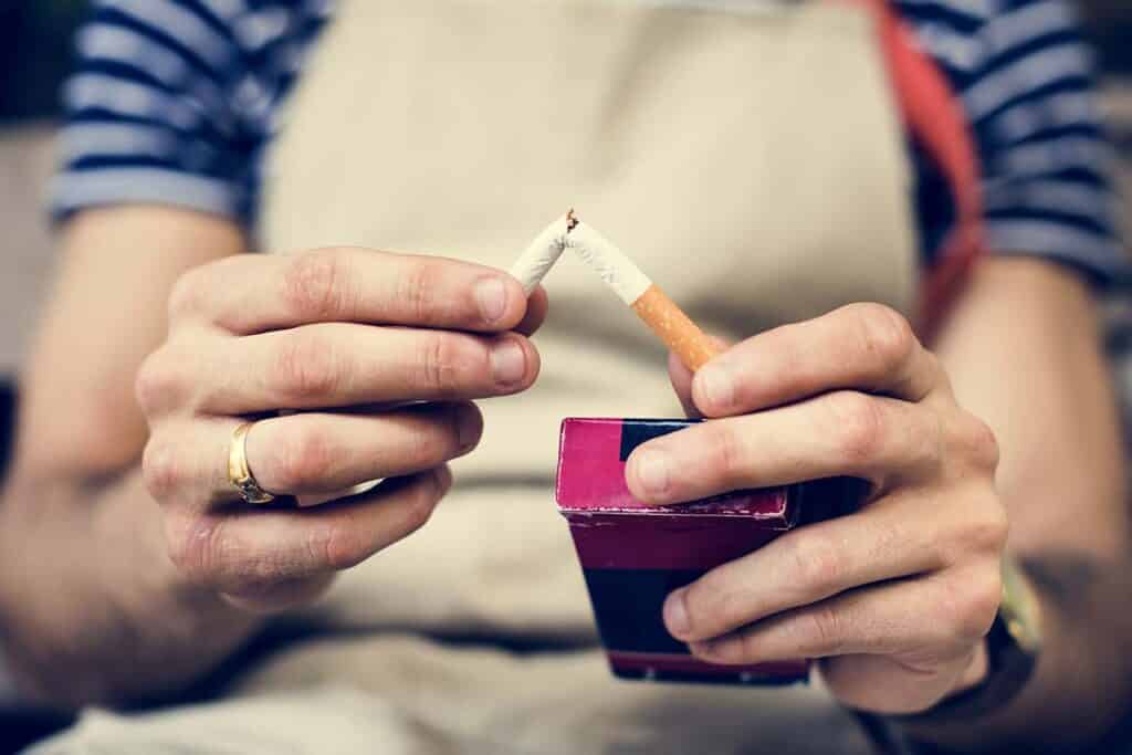 Smoker breaking a cigarette in half